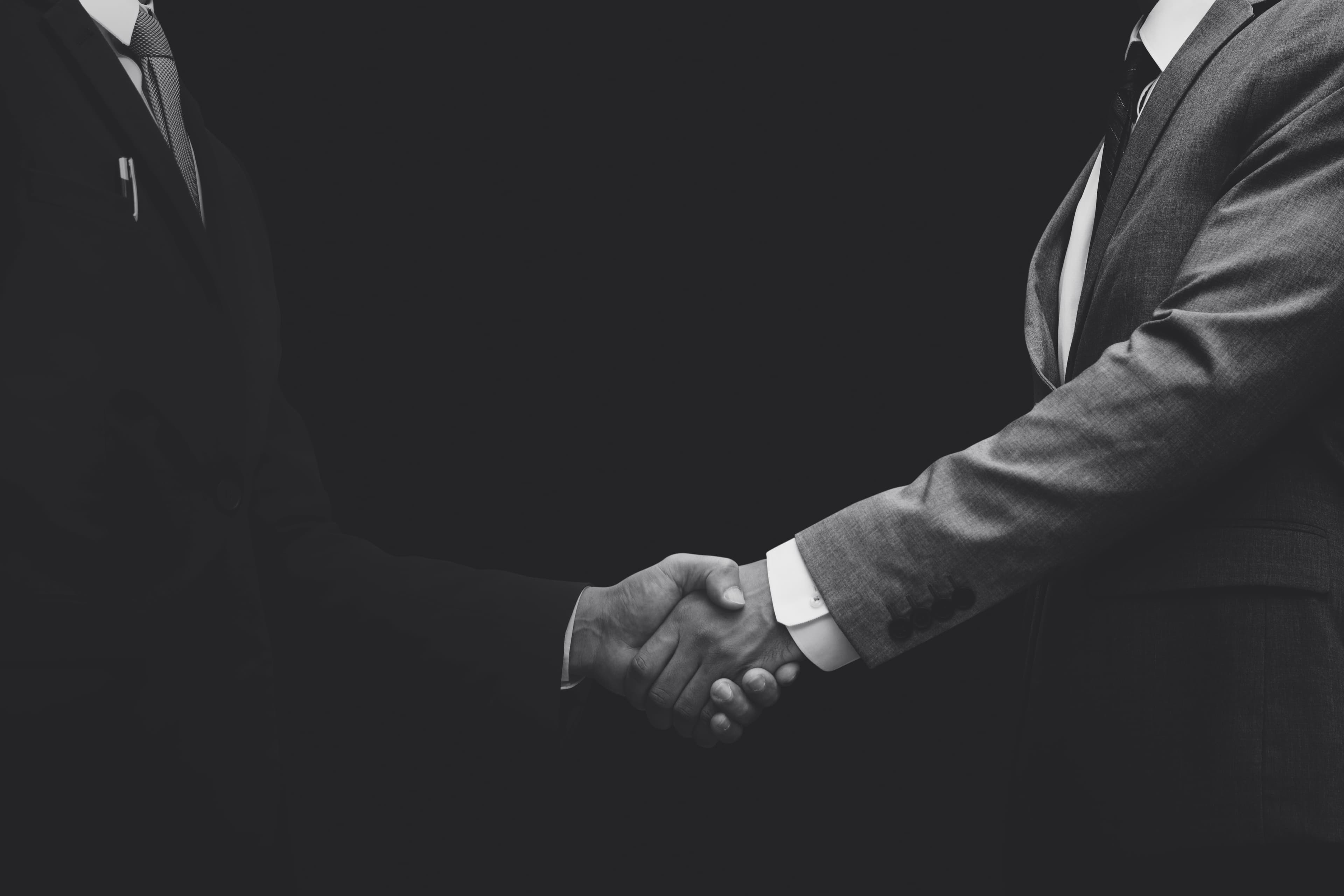 Close-up of a handshake between two people in suits