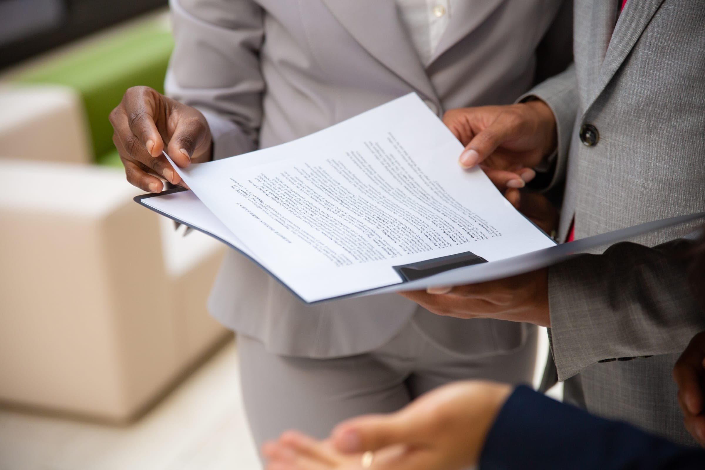 Colleagues in business suits reviewing a printed document together