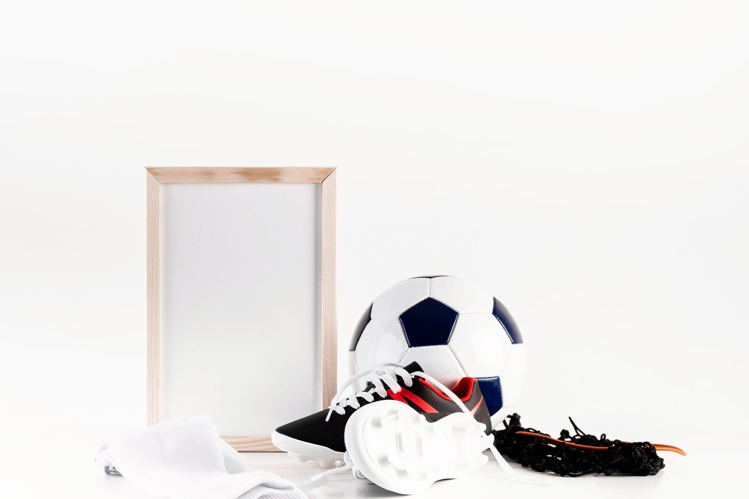A football, boots and kit arranged beside an empty wooden frame